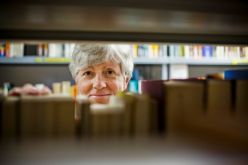 woman looking through bookshelf